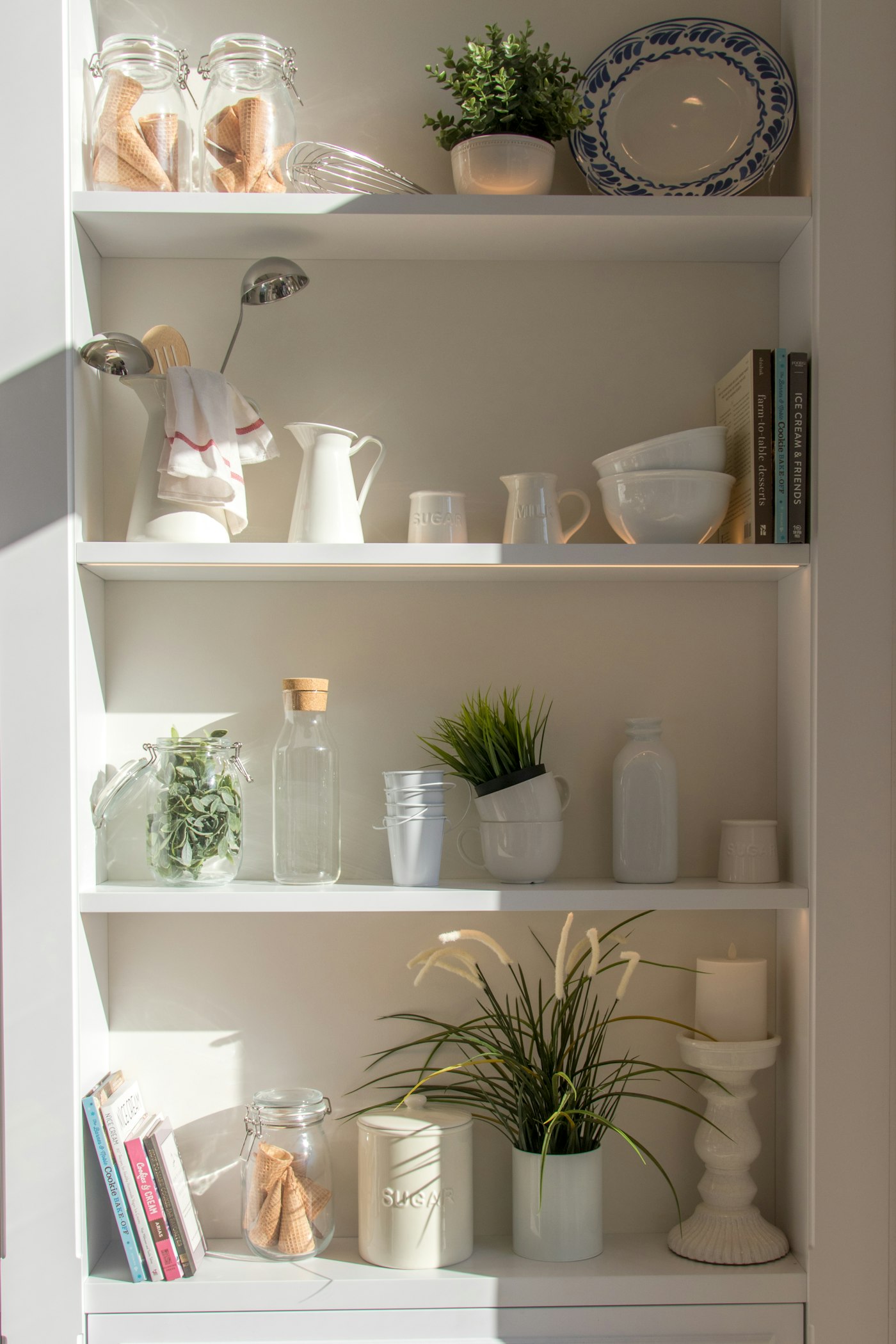 Gestylede plank met vazen, kaarsen en decoratie in warme tinten